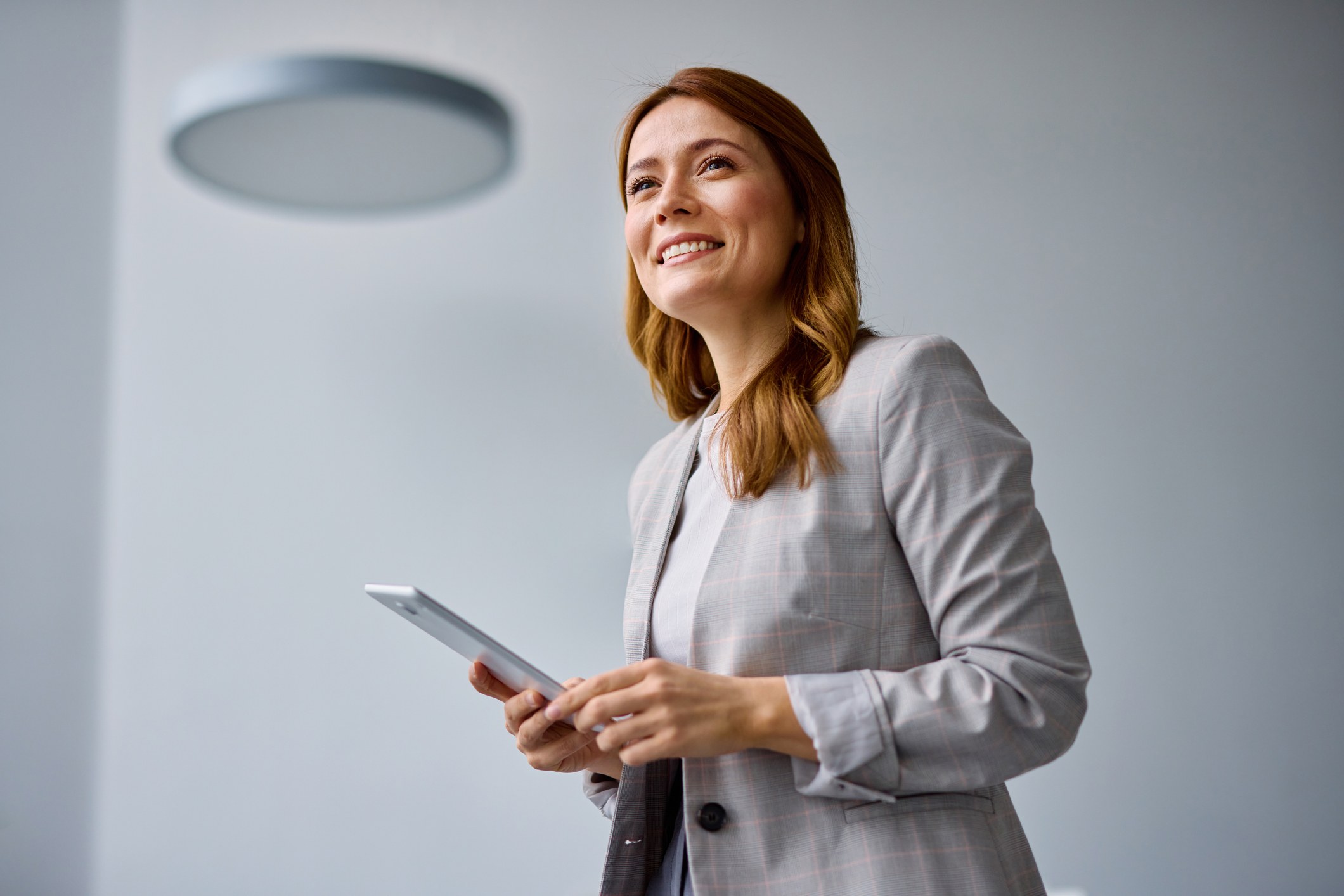 Broker holding a tablet, looking ahead